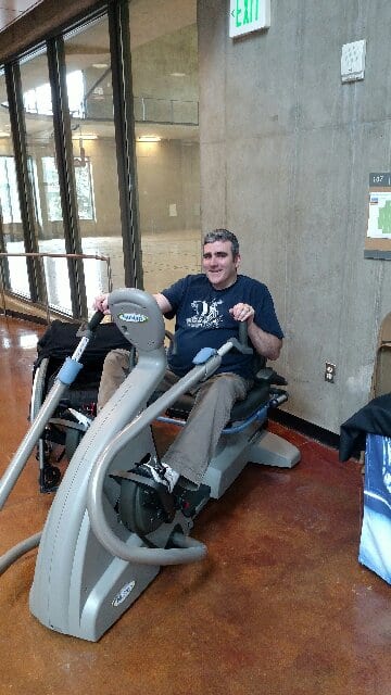 DAC Staffer, Jacob Kinser, tries out the Wade King Rec Center's new accessible NuStep machine at Vikings on Wheels.